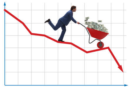 Businessman pushing money wheelbarrow down the chartの写真素材