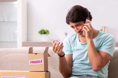 Man opening fragile parcel ordered from internetの写真素材