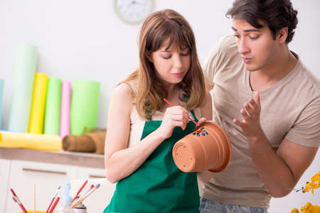 Couple decorating pots in workshop during classの写真素材