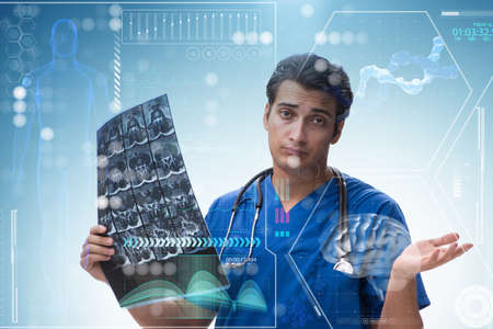 Young doctor looking at x-ray image in mhealth conceptの写真素材