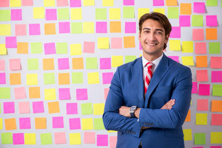 Young handsome man in conflicting priorities conceptの写真素材