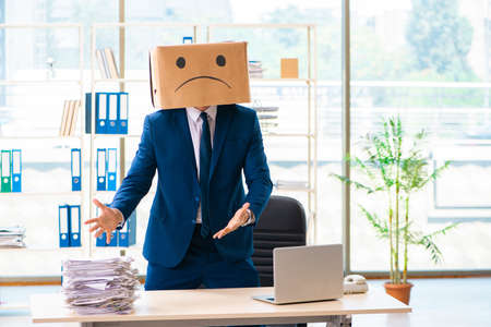 Unhappy man with box instead of his headの写真素材