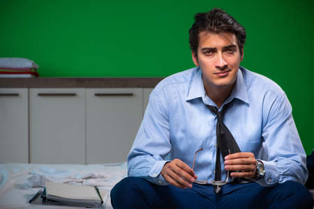 Young businessman under stress in the bedroom at nightの写真素材