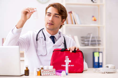 Young doctor with first aid kit in hospitalの写真素材