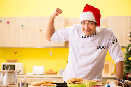 Young chef husband working in kitchen at Christmas eveの写真素材