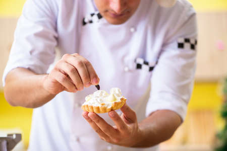 Young chef husband working in kitchen at Christmas eveの写真素材