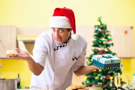 Young chef husband working in kitchen at Christmas eveの写真素材