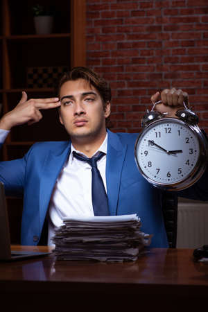 Young businessman working in the office at nightの写真素材