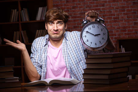 Young handsome student preparing for exams at nightの写真素材