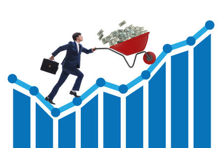 Businessman pushing wheelbarrow full of dollar moneyの写真素材