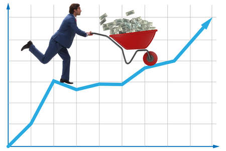 Businessman pushing wheelbarrow full of dollar moneyの写真素材