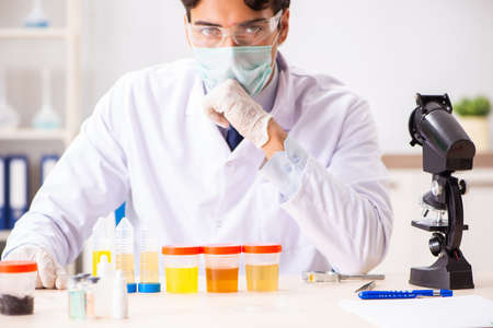 Young handsome chemist working in the lab