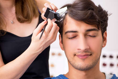 Young attracrive man visiting female barberの写真素材