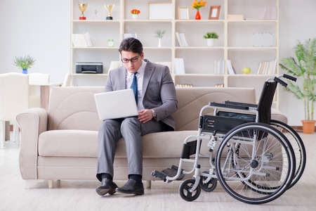 Dsabled businessman on wheelchair working homeの写真素材