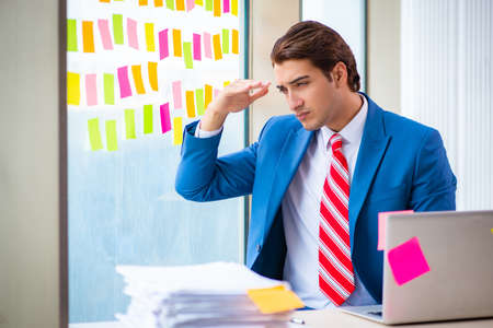 Young handsome employee with many conflicting prioritiesの写真素材