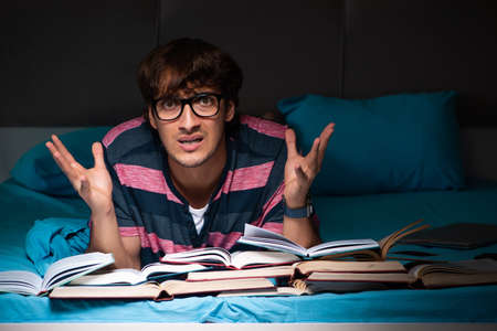 Young student preparing for exams at night at home