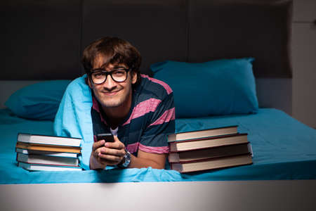 Young student preparing for exams at night at homeの写真素材
