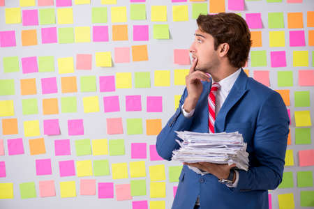 Young handsome man in conflicting priorities conceptの写真素材