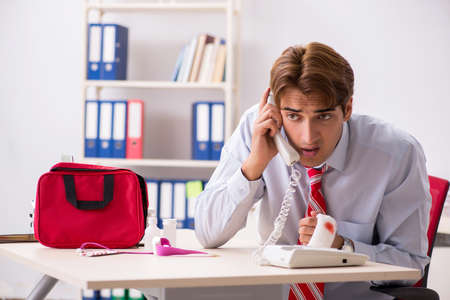 Man with first aid kit in the officeの写真素材