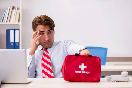 Man with first aid kit in the officeの写真素材