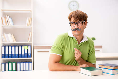 Student with fake moustache reading bookの写真素材