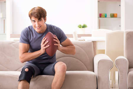 Injured man recovering at home from sports injuryの写真素材