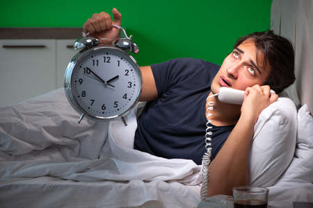 Young handsome man suffering from insomnia at homeの写真素材