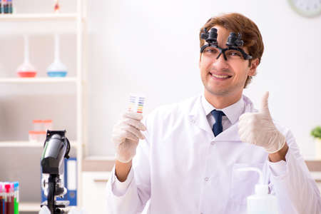 Chemist in the lab checking with ph stripsの写真素材