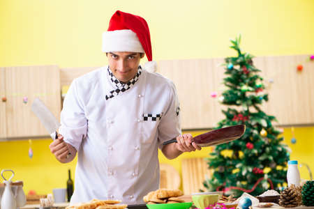 Young chef husband working in kitchen at Christmas eveの写真素材