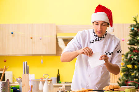 Young chef husband working in kitchen at Christmas eveの写真素材