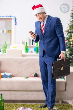 Young handsome employee celebrating Christmas at workplaceの写真素材
