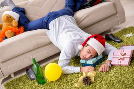 Young handsome employee celebrating Christmas at workplaceの写真素材