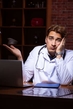 Young handsome doctor working night time at the hospitalの写真素材