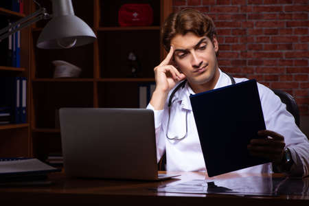Young handsome doctor working night time at the hospitalの写真素材