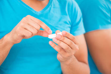 Man trying contact lenses at home