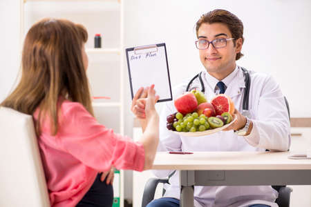 Pregnant woman visiting doctor discussing healthy dietの写真素材