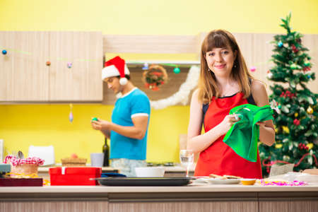 Young couple celebrating Christmas in kitchenの写真素材
