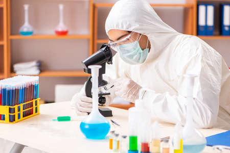 Young biochemist wearing protective suit working in the lab