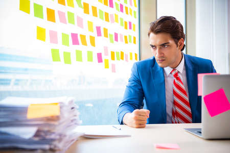 Young handsome employee with many conflicting prioritiesの写真素材