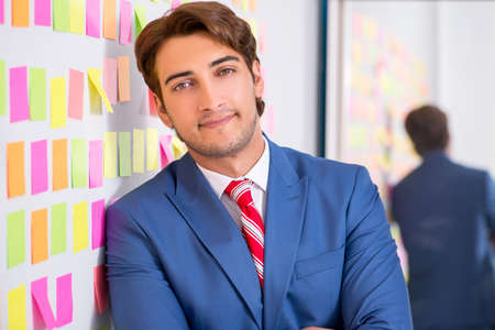 Young handsome man in conflicting priorities conceptの写真素材