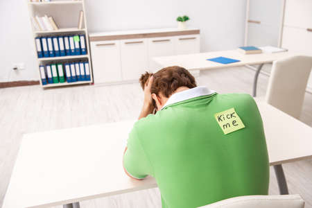 Office prank with kick me message on sticky noteの写真素材