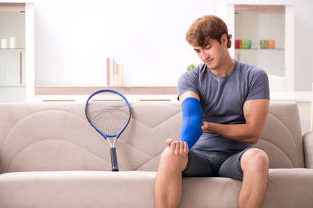 Injured man recovering at home from sports injuryの写真素材