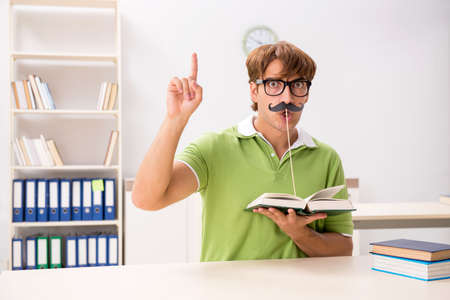 Student with fake moustache reading bookの写真素材