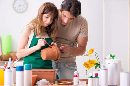 Couple decorating pots in workshop during classの写真素材