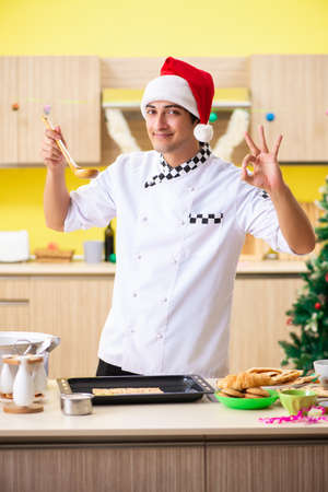 Young chef husband working in kitchen at Christmas eveの写真素材