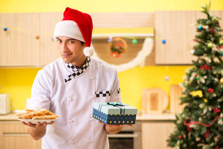Young chef husband working in kitchen at Christmas eveの写真素材