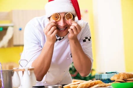 Young chef husband working in kitchen at Christmas eveの写真素材