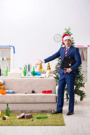 Young handsome employee celebrating Christmas at workplaceの写真素材