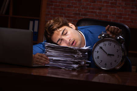 Young businessman working in the office at nightの写真素材