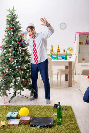 Young handsome employee celebrating Christmas at workplaceの写真素材